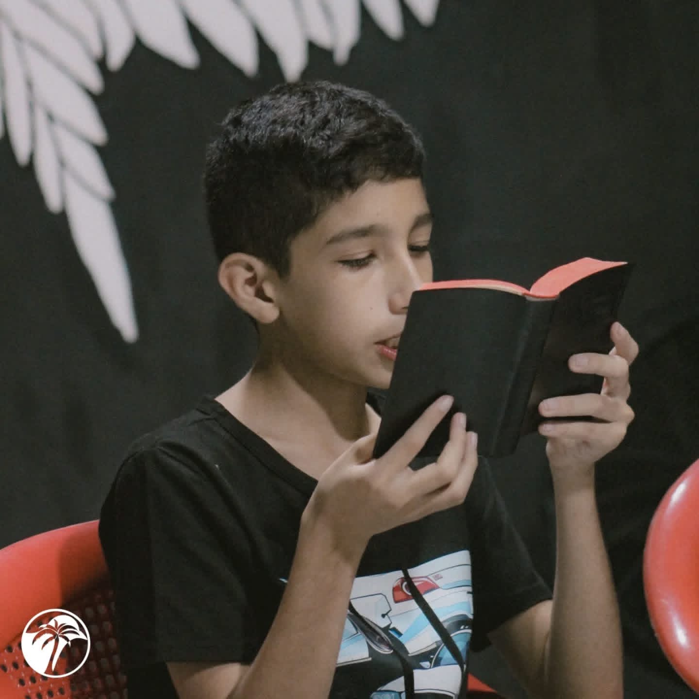 Niño leyendo la Biblia en Oasis de Amor